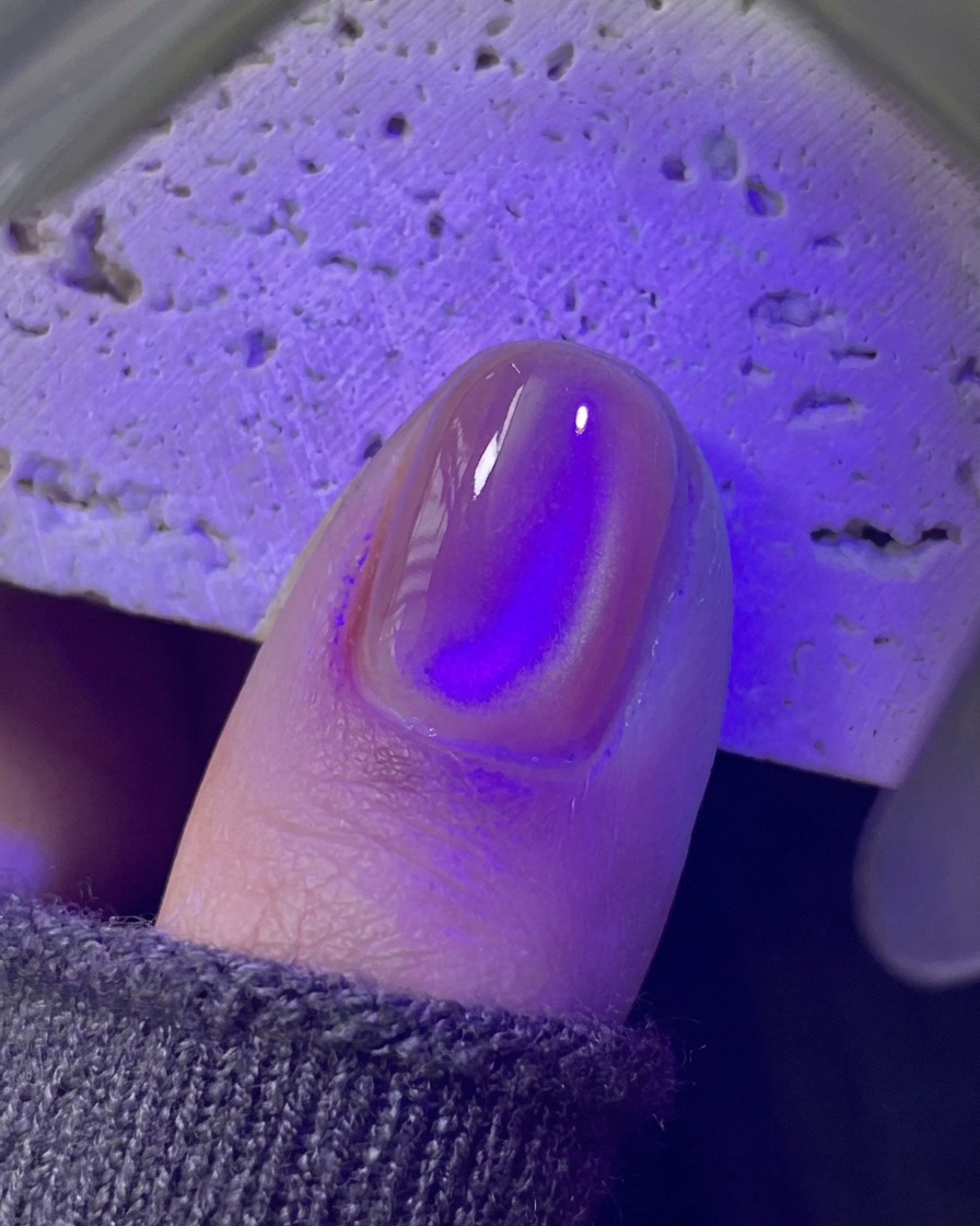 Un onglet en train de catalyser sous une mini lampe UV/LED violette.