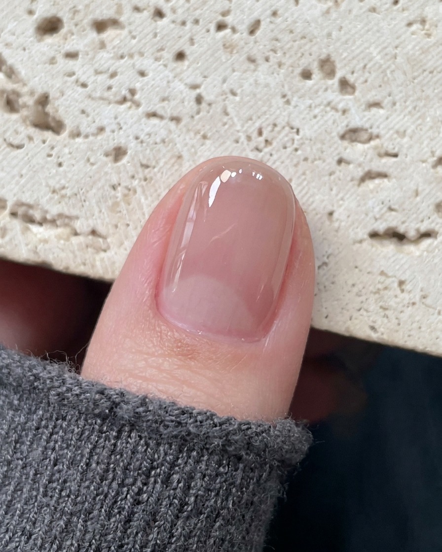 Une pince de précision plaçant un délicat autocollant en forme détoile creuse au centre dun ongle catalysé.