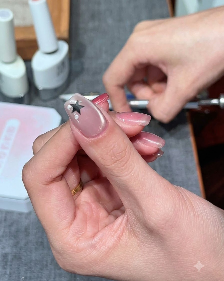 Un tampon éponge non pelucheux tapotant du gel blanc laiteux autour dun autocollant détoile sur un ongle.