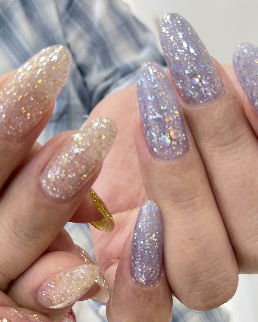 Gros plan dongles texturés à paillettes violettes avec une ligne de cuticule soignée.
