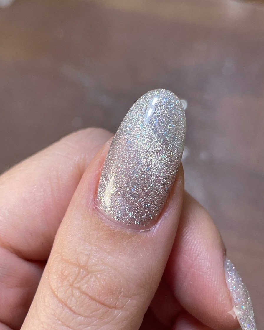 Un outil magnétique planant au-dessus dun ongle en gel scintillant pour mettre en place les particules de paillettes magnétiques.