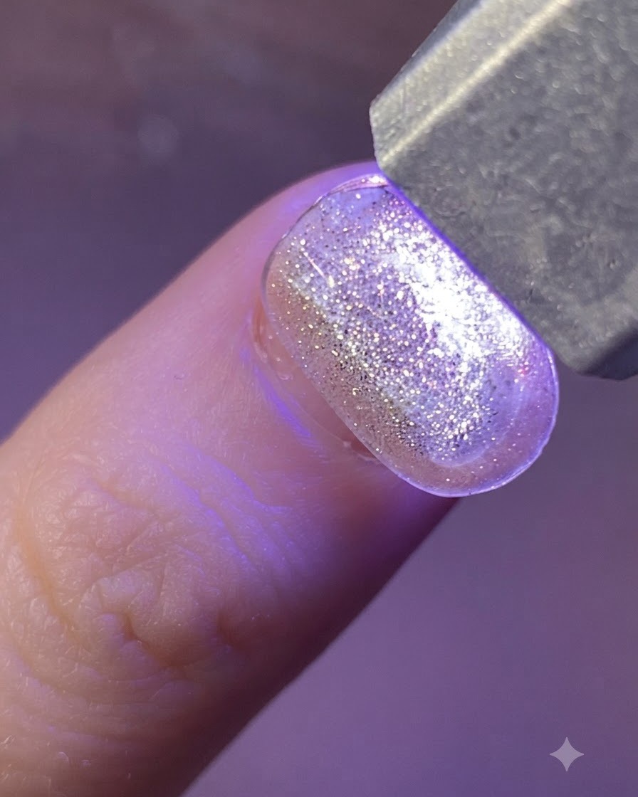 Une pince à épiler en métal soulevant un autocollant étoile holographique de sa feuille transparente.