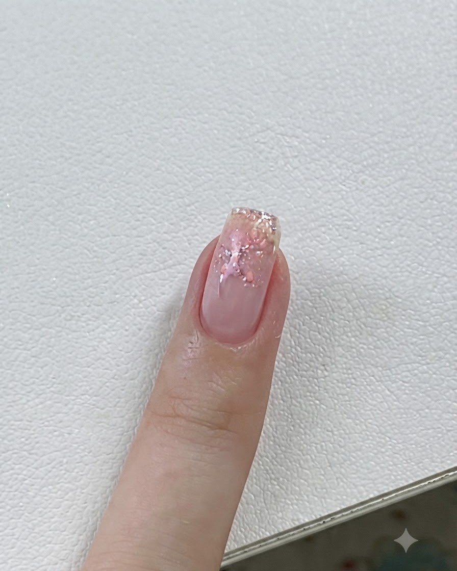 Gros plan dun ongle en train de catalyser sous une lampe UV/LED avec des détails roses et des étoiles.