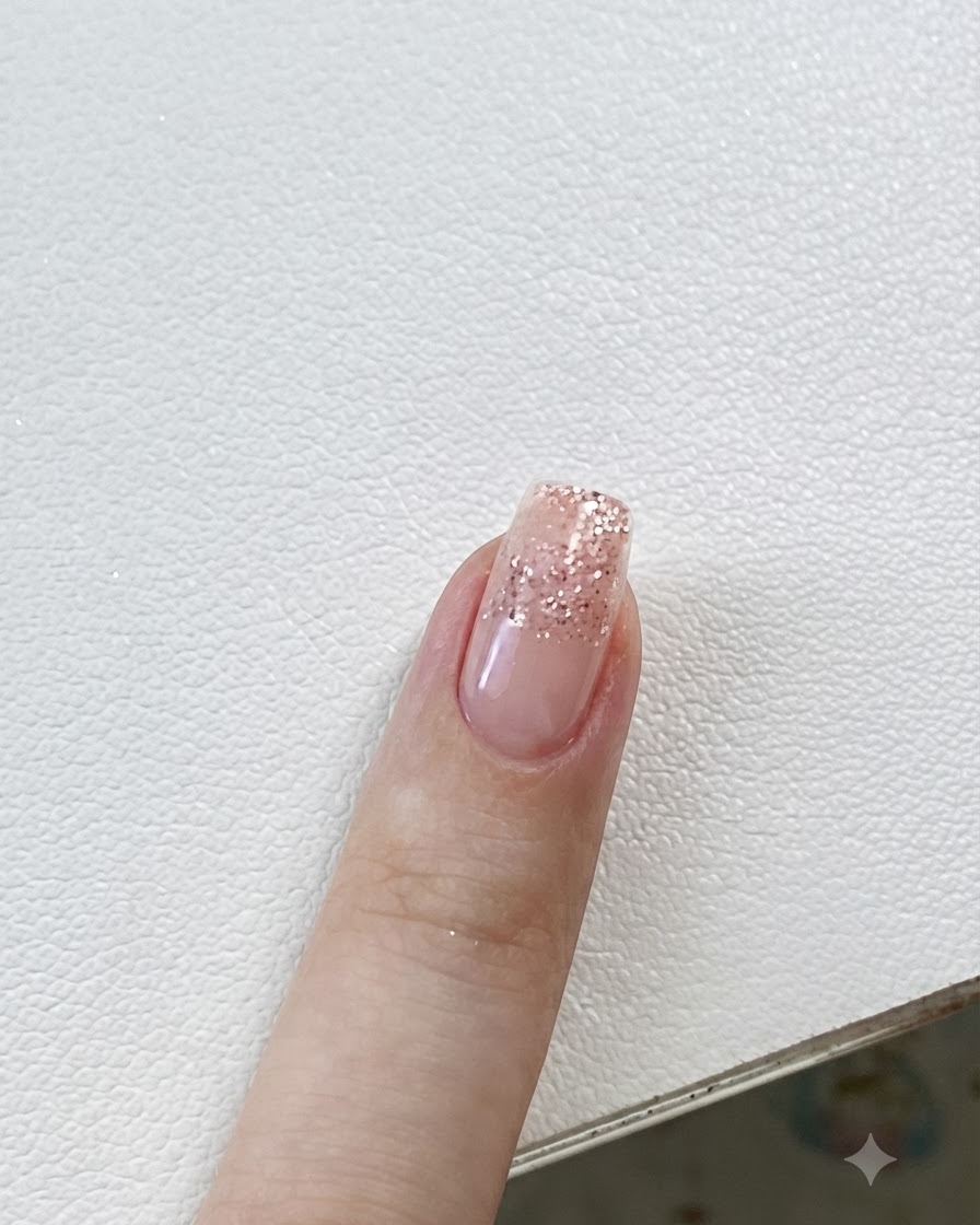 Une pince plaçant un petit sticker étoile sur un ongle au dégradé pailleté.