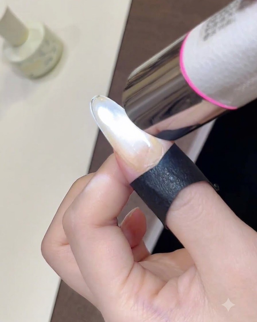 Gros plan dune mini lampe UV portative catalysant un vernis gel œil-de-chat scintillant fraîchement façonné sur un ongle.