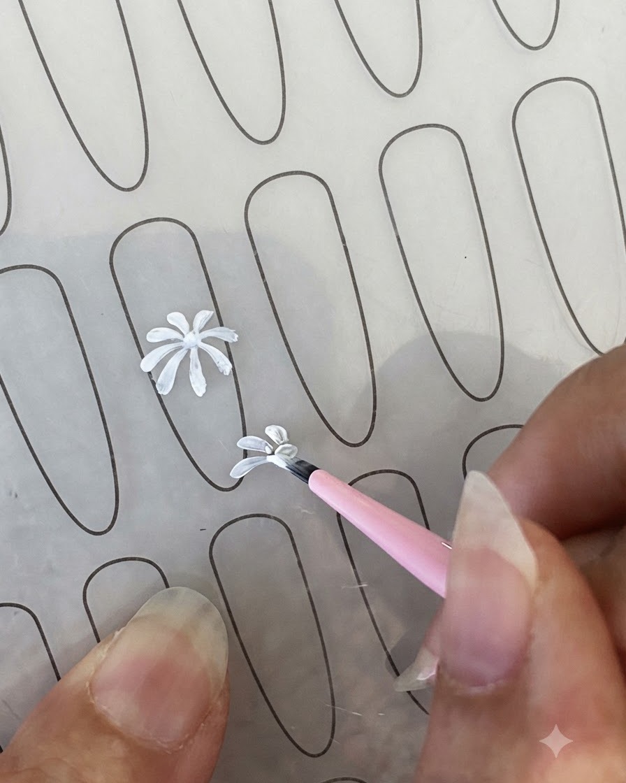 Un contour de pétale de marguerite blanche fini sur une feuille dentraînement à côté dun pinceau fin.