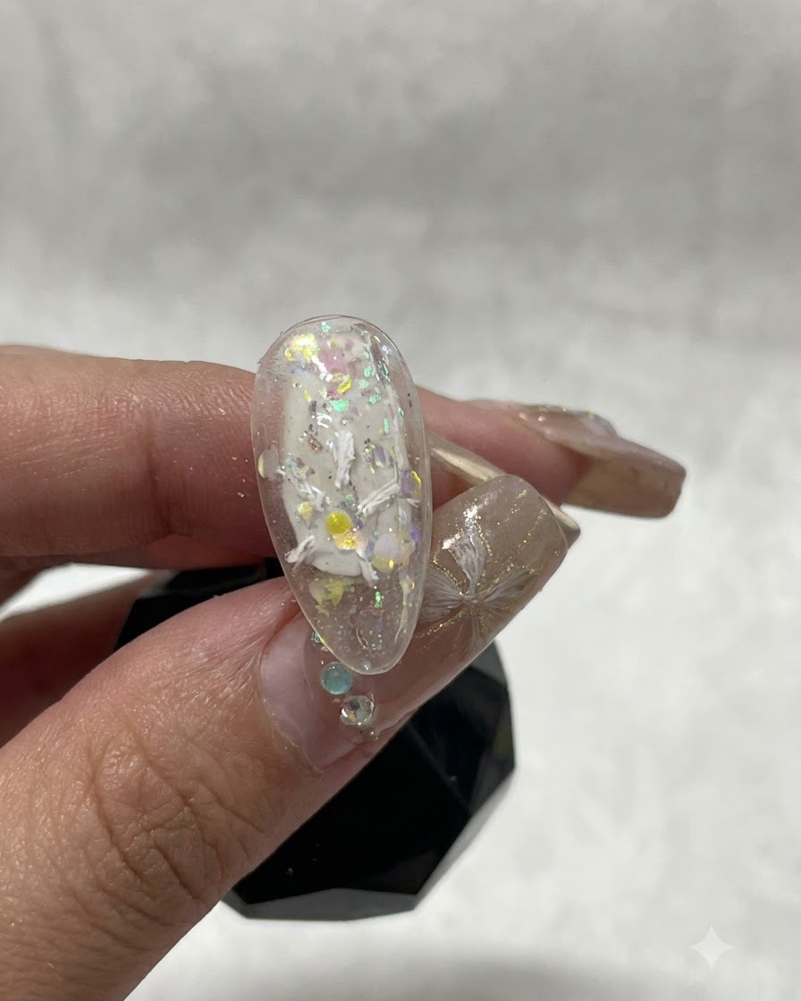 Vue rapprochée dun ongle montrant les premiers traits de gel plâtre blanc formant le début dun motif floral.