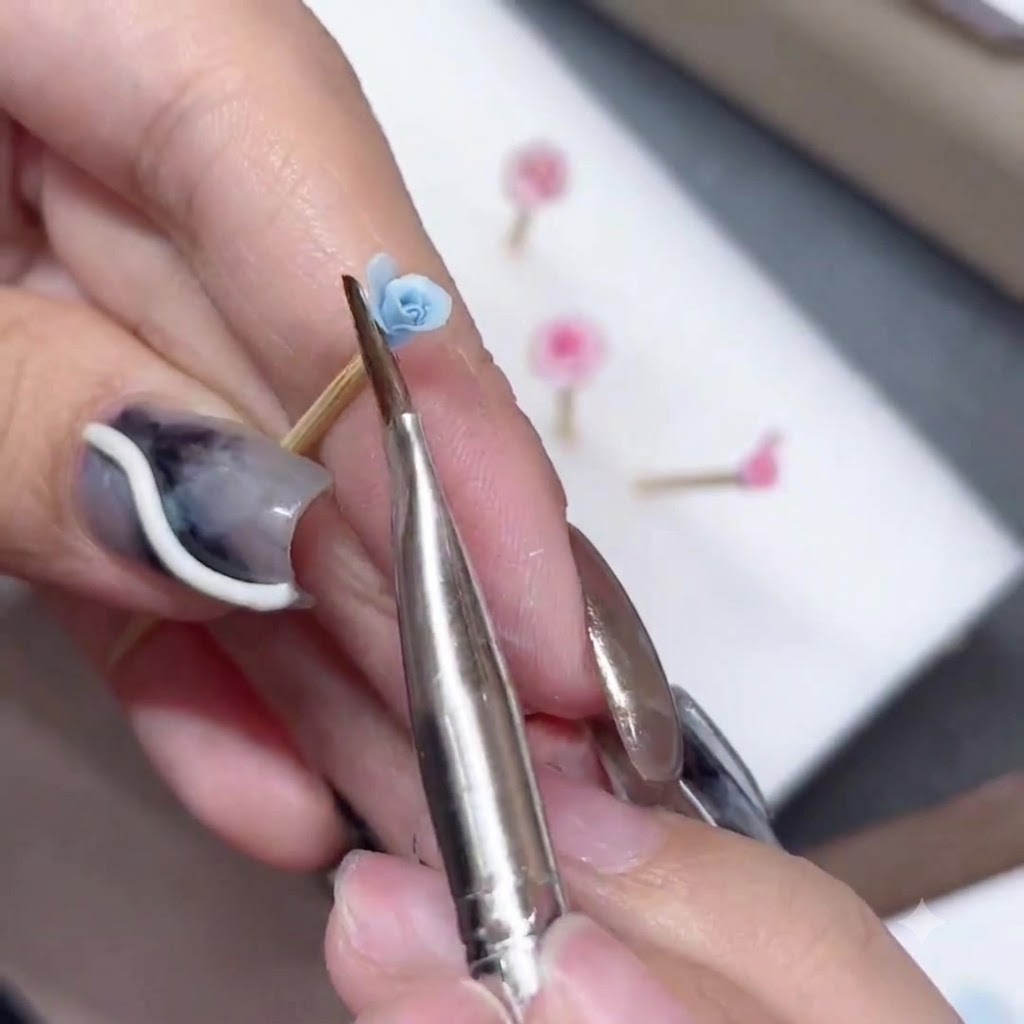 Un pinceau en silicone sculptant et évasant le bord dun pétale de rose bleue.