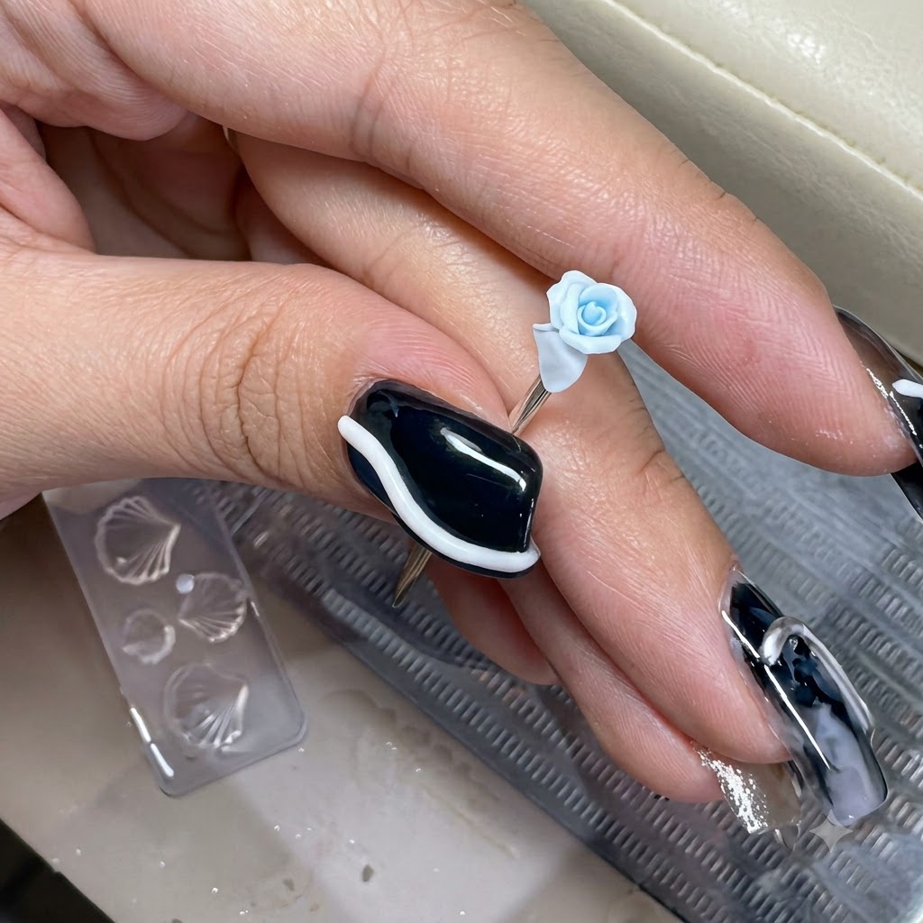 Un minuscule pétale en argile bleu clair en train dêtre placé sur le bord extérieur dune rose miniature sculptée.