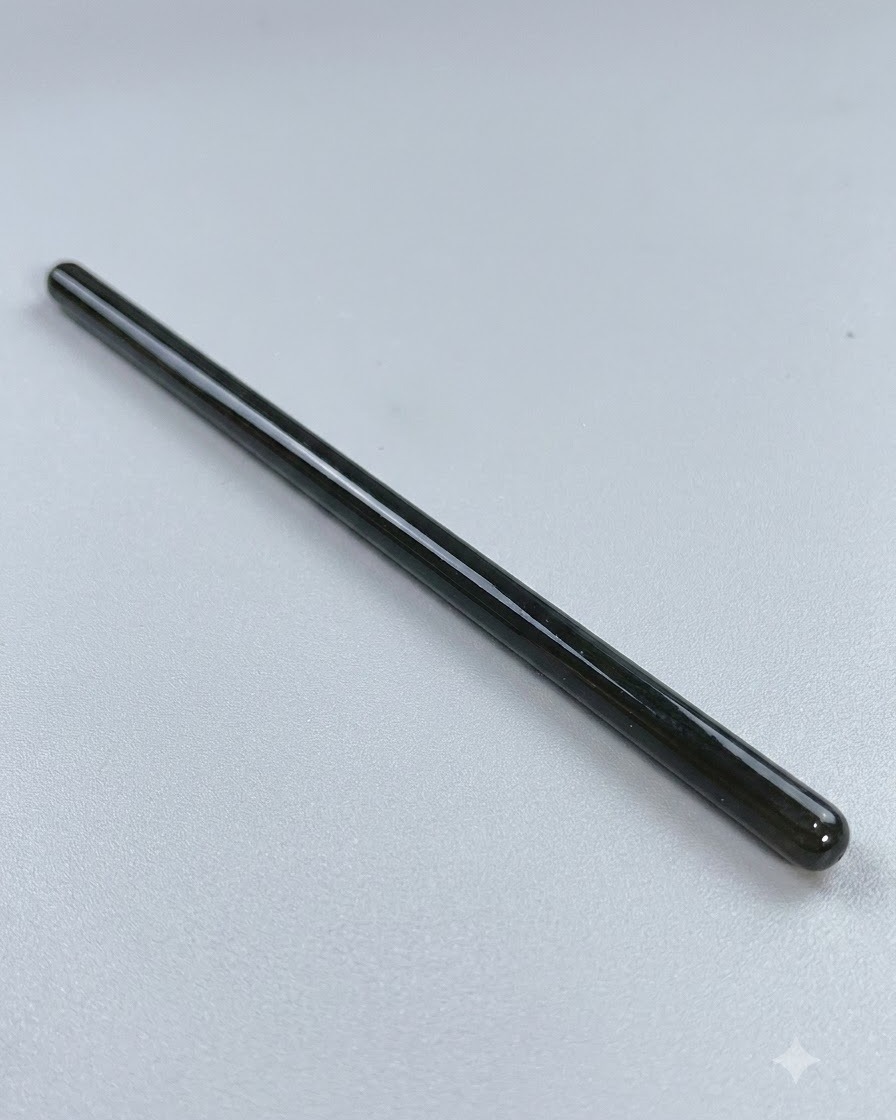 Un pinceau de nail art fin et long posé sur une surface propre avant le travail de lignes détaillées.