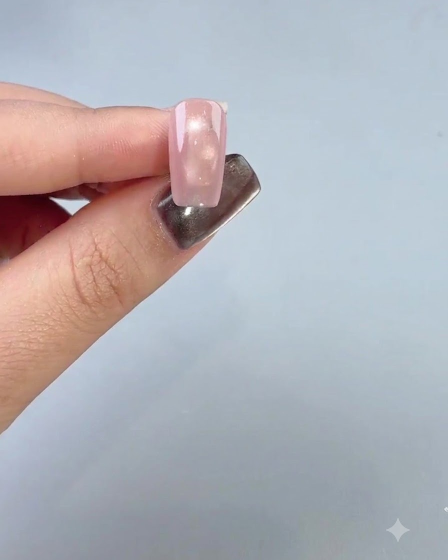 Un doigt manucuré affichant une couche de base lisse appliquée sur le quatrième ongle.