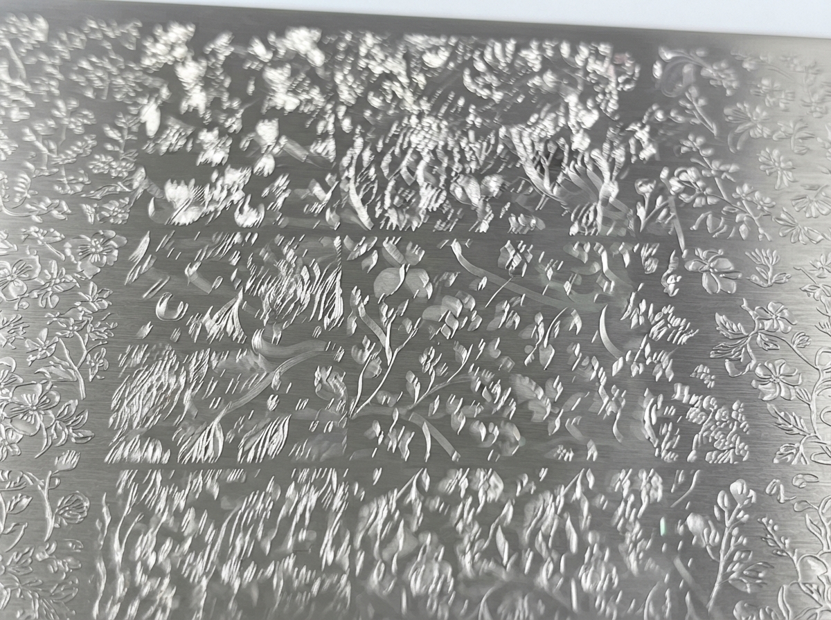 Vue rapprochée dune plaque de stamping en métal gravée de motifs floraux détaillés.