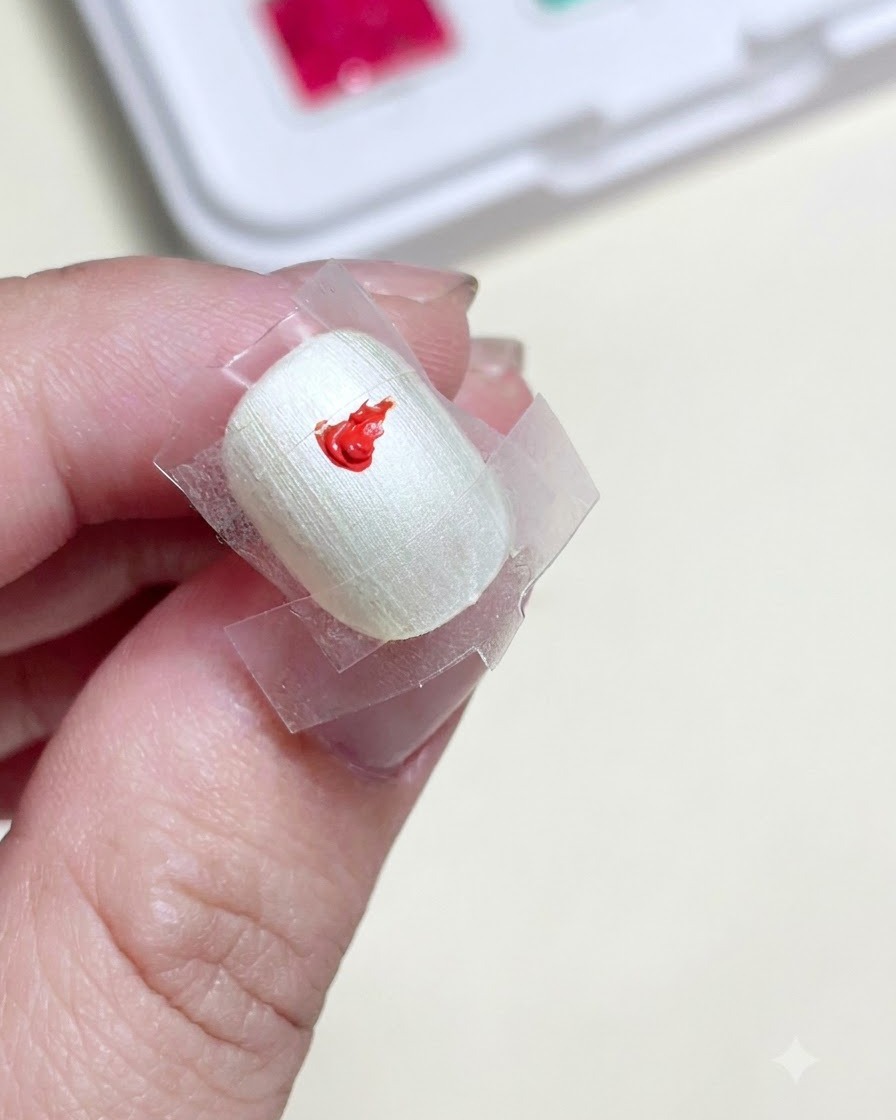 Gros plan dun ongle préparé avec un carré délimité au centre, comportant une touche de gel paint rouge vif.