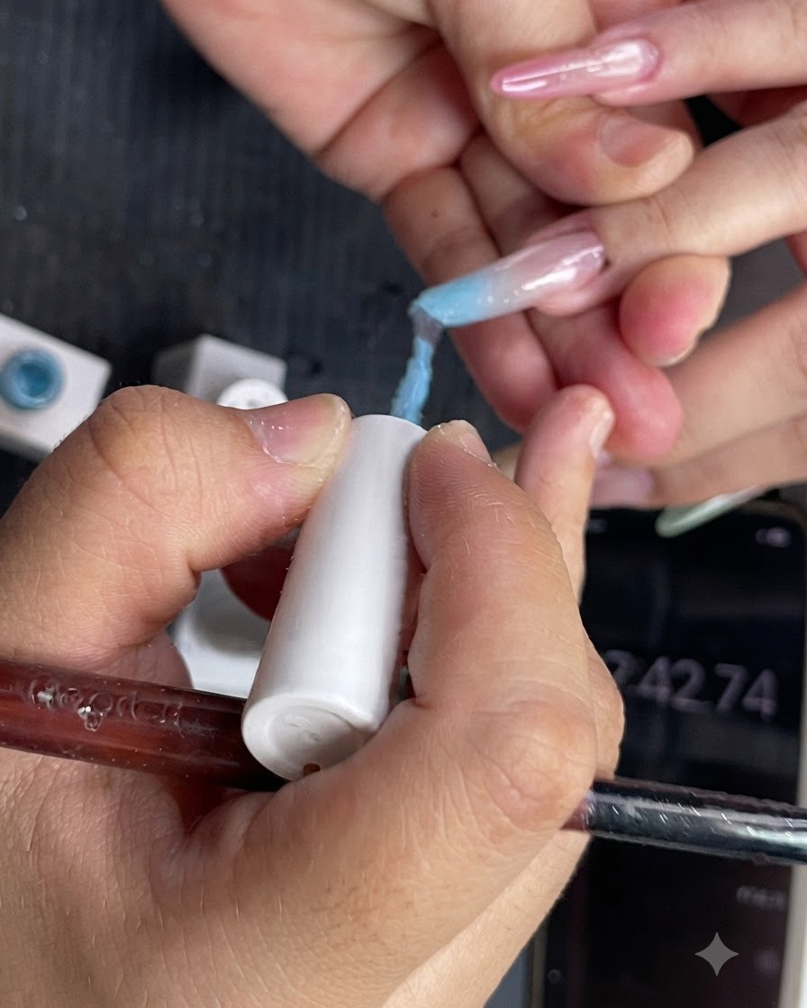 Gros plan de lapplication dun vernis gel bleu clair sur la moitié supérieure dun ongle.