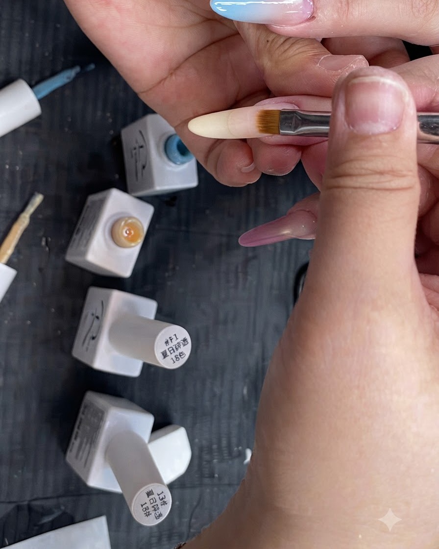 Un pinceau plat à dégradé estompant un gel jaune translucide vers le bas sur un long ongle en forme damande.