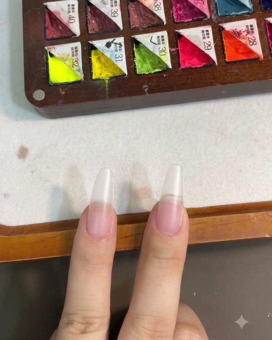 Ongles présentés après la catalyse de la couche de base sous une lampe UV ou LED.