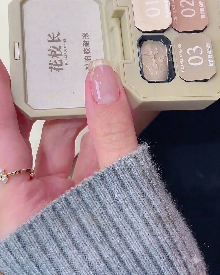 Gros plan dun ongle naturel sur lequel une base blanche est appliquée près du bord libre.