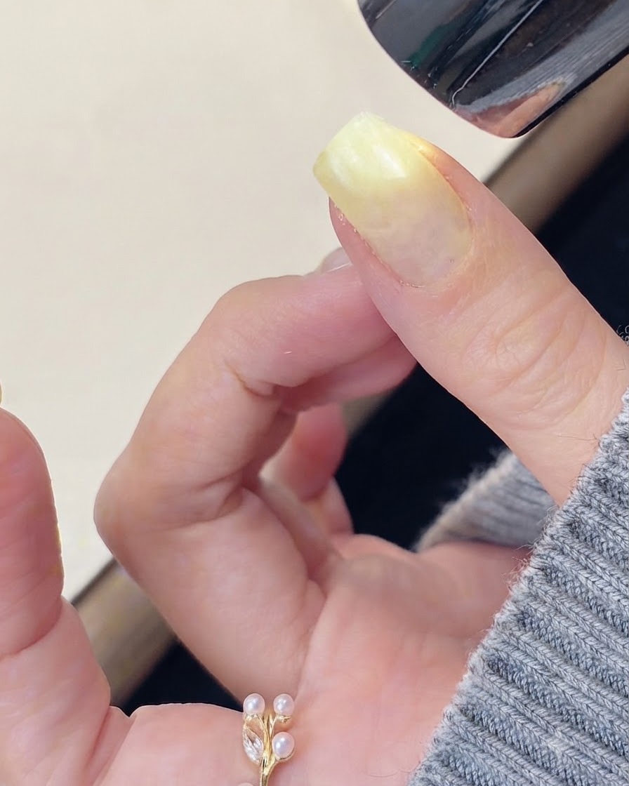 Un pinceau appliquant un gel de construction transparent sur la surface dun ongle préparé.