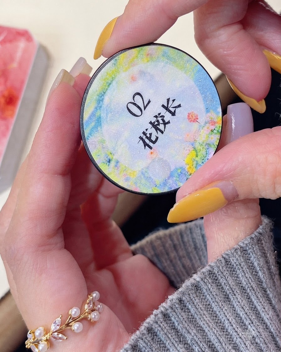 Une main tenant un pot rond de produit en gel couleur étiqueté avec des caractères asiatiques.