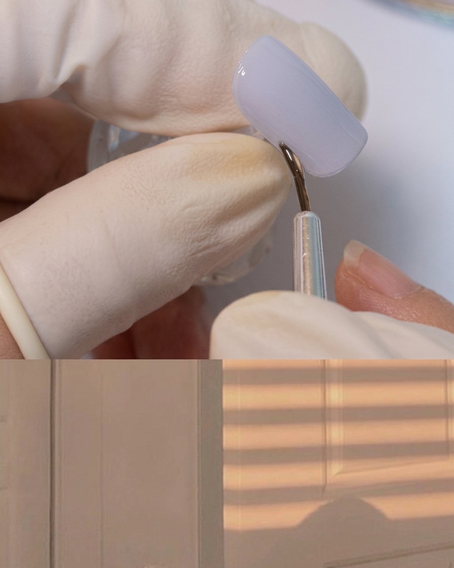 Un pinceau liner fin appliquant un gel adhésif épais autour de la bordure dun ongle gris mat.