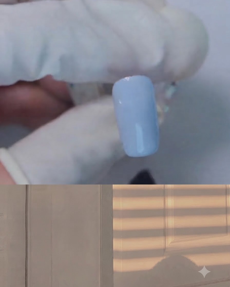 Un pinceau appliquant du gel blooming transparent sur un ongle bleu clair.