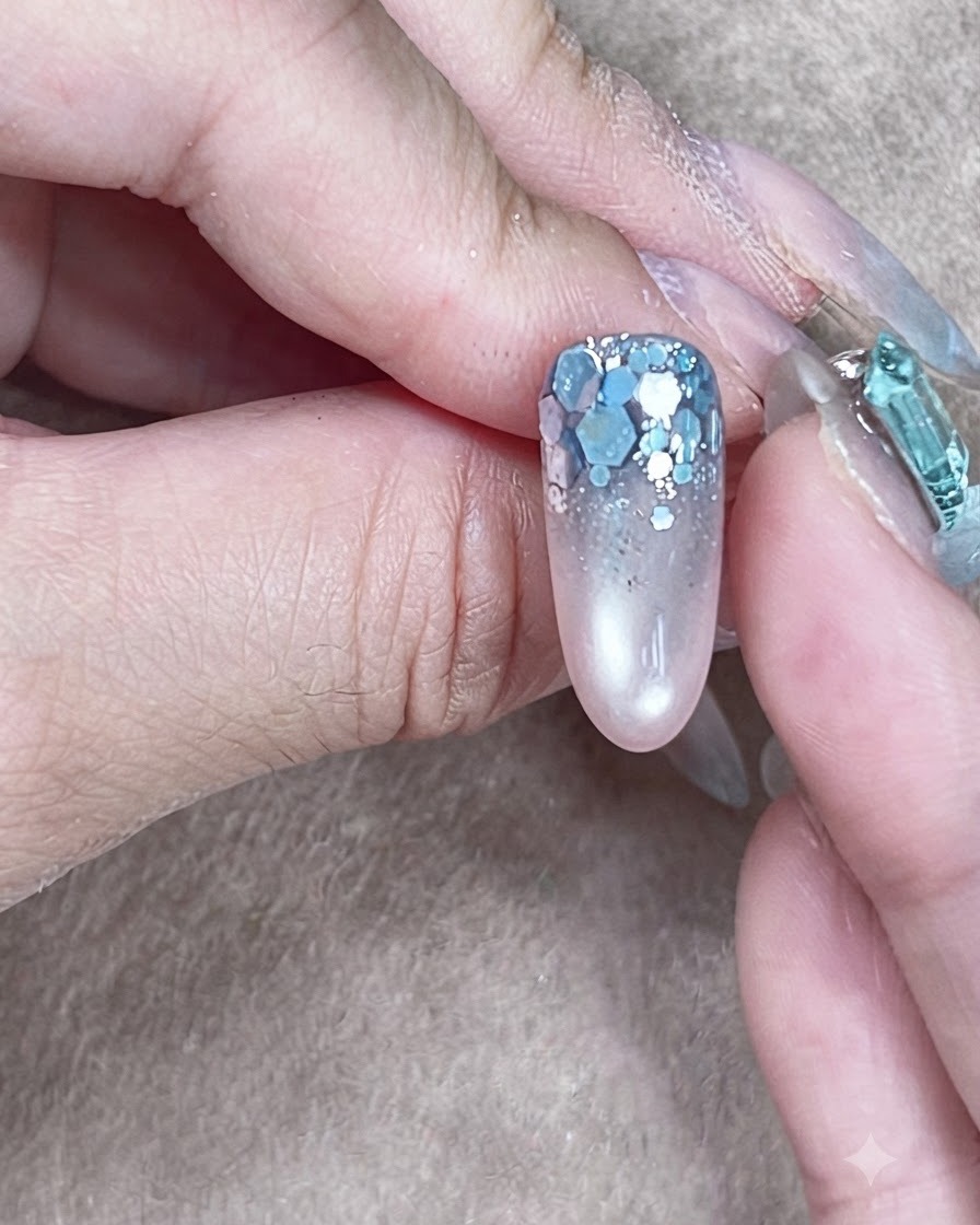 Une structure dongle achevée avec un gel de construction transparent auto-égalisé enveloppant le nail art pailleté.