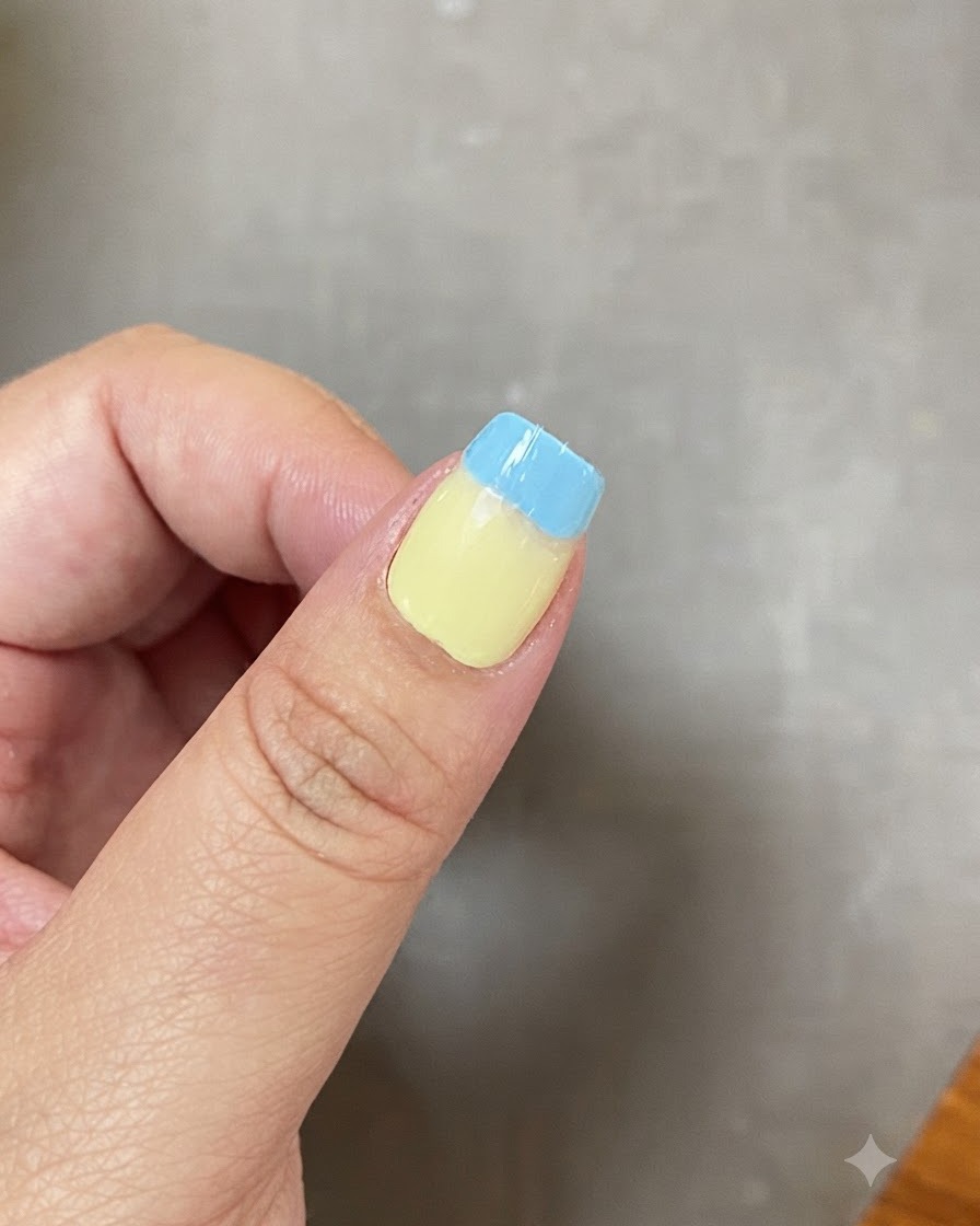 Un ongle présentant une transition dégradée et fondue entre le vert clair et le bleu clair.