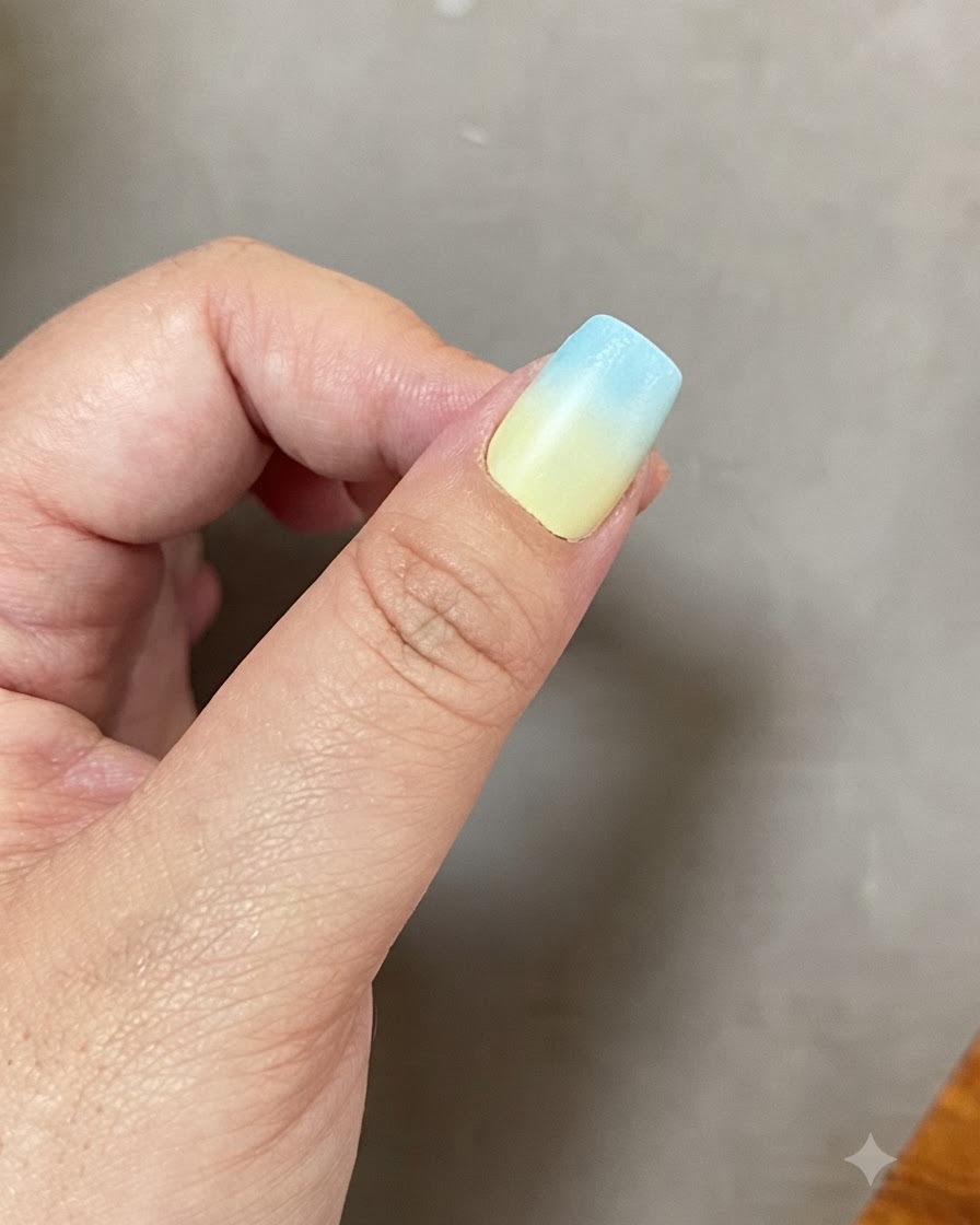 Un ongle avec un dégradé de bleu et de jaune en train de catalyser à lintérieur dune lampe UV LED.