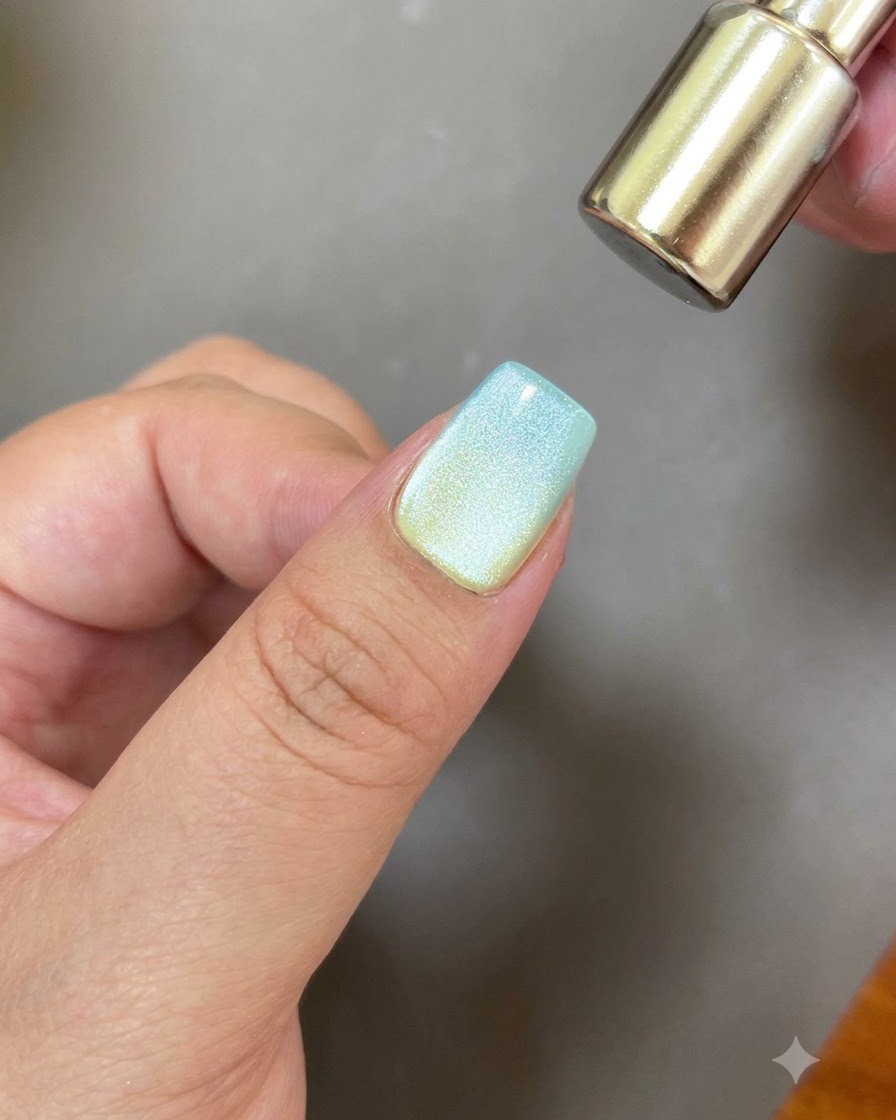 Lextrémité arrondie dun outil magnétique survolant un ongle pour créer un reflet cat eye circulaire.