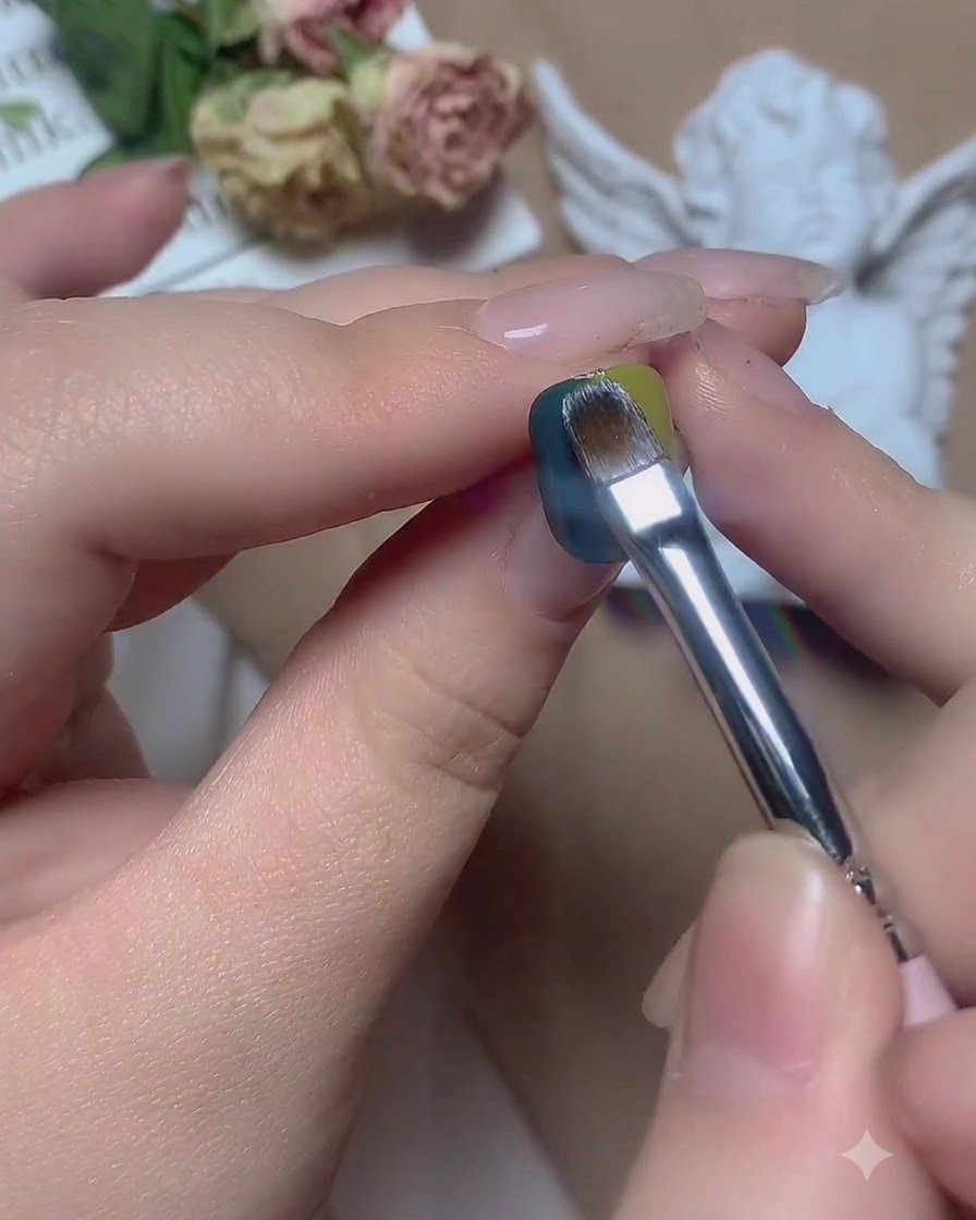 Un pinceau balayant horizontalement la limite centrale entre le gel vert et le gel bleu.