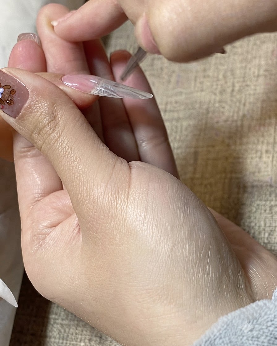 Gros plan dun pinceau de détail lissant du gel transparent sur la surface dune extension dongle.