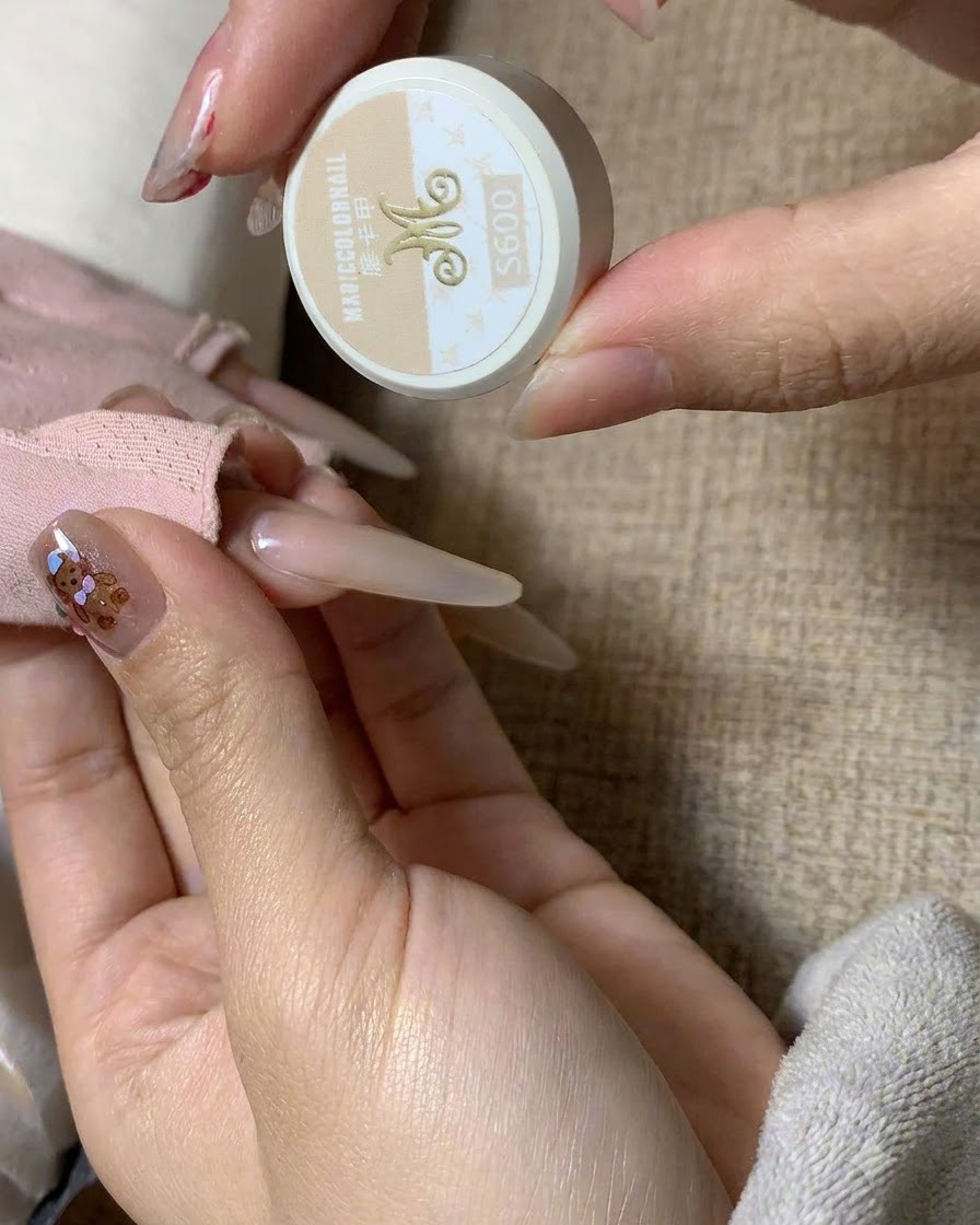 Gros plan dun pinceau fin trempant dans un pot de gel de couleur thé au lait MC Mocha.