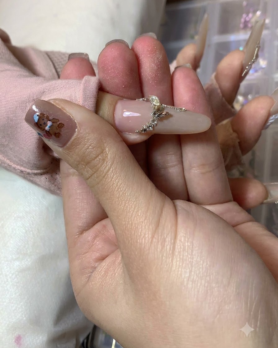 Une prothésiste ongulaire ajoutant des traits daccentuation blancs finaux le long des bords extérieurs du nail art papillon terminé.