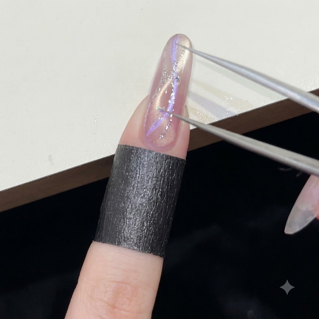 Une pince de précision plaçant de minuscules sequins en forme détoile argentée sur la surface dun ongle en gel humide.