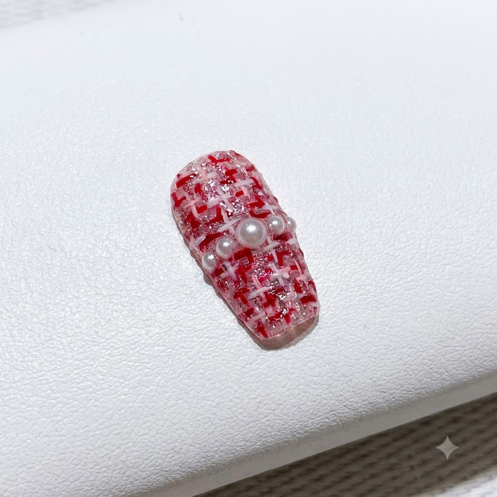 Un pinceau fin remplissant un vernis gel rouge vif sur un côté dune French manucure en forme de V.