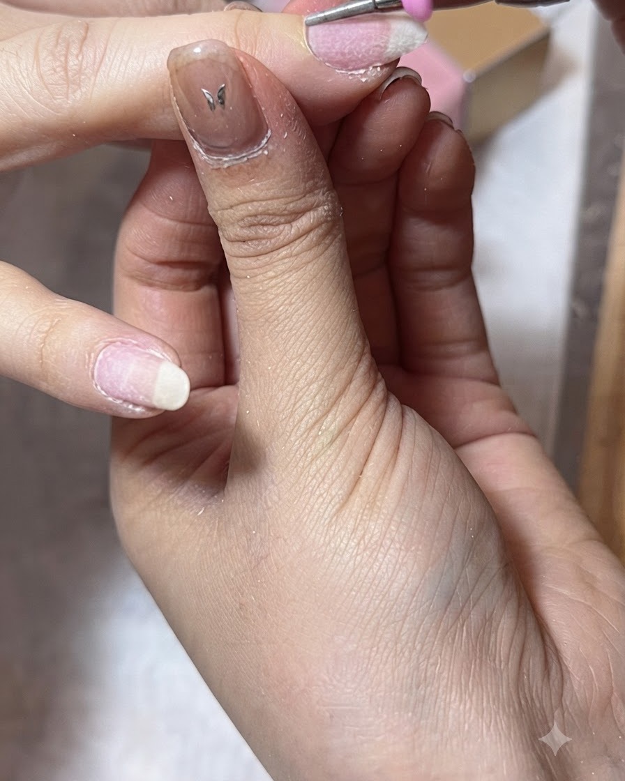 Une ponceuse nettoie les replis latéraux dun ongle de pouce lors de la préparation des cuticules.