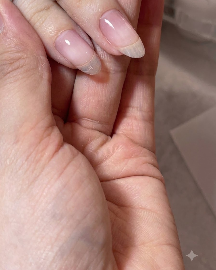Une main présente un ongle en gel transparent parfaitement structuré affichant un apex régulier.