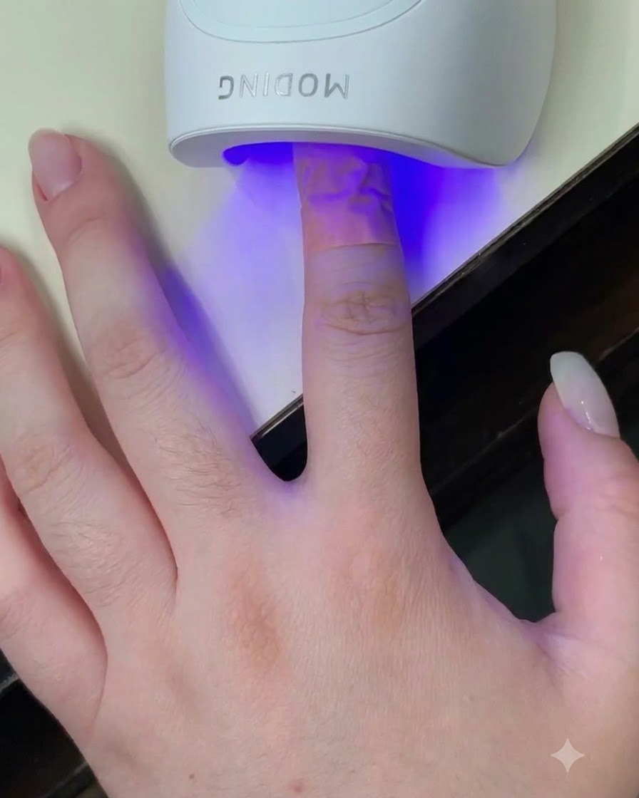 Un doigt placé à lintérieur dune mini lampe UV LED blanche avec une lumière bleue éclairant longle.