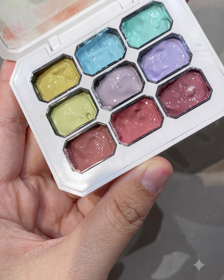 Une palette de gel multicolore montrant diverses teintes pastel, y compris le vert cyan et des roses poudrés.