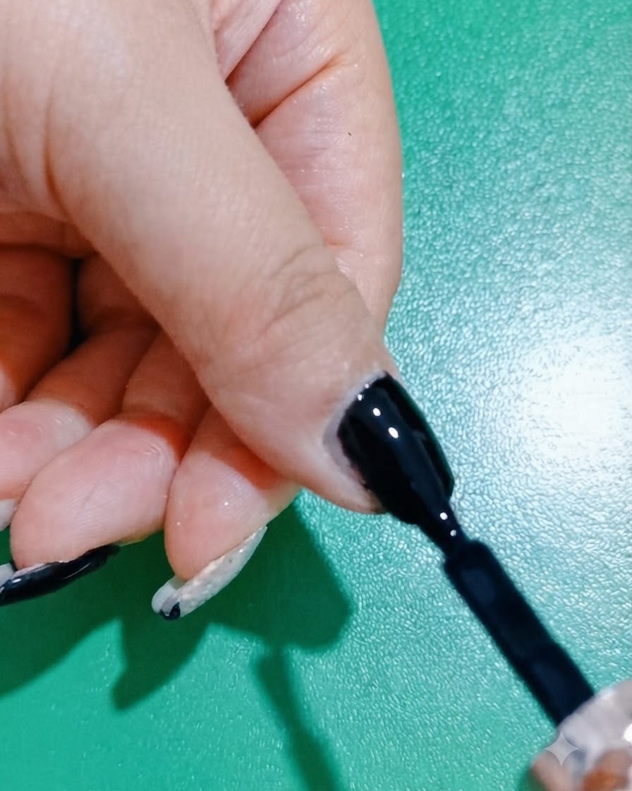 Un pinceau lissant et raffinant une couche de vernis gel noir sur un onglet.