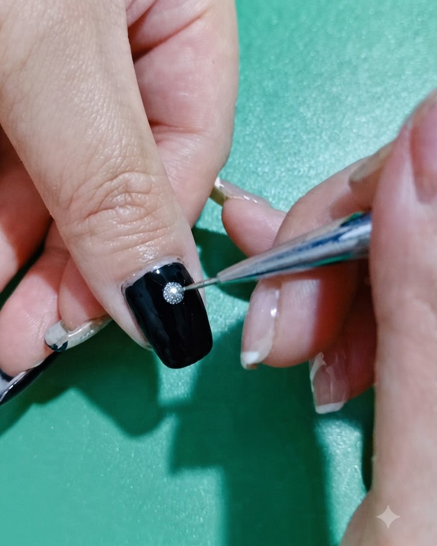 Un pinceau liner fin trempant dans un pot de gel pailleté argent et or rose.