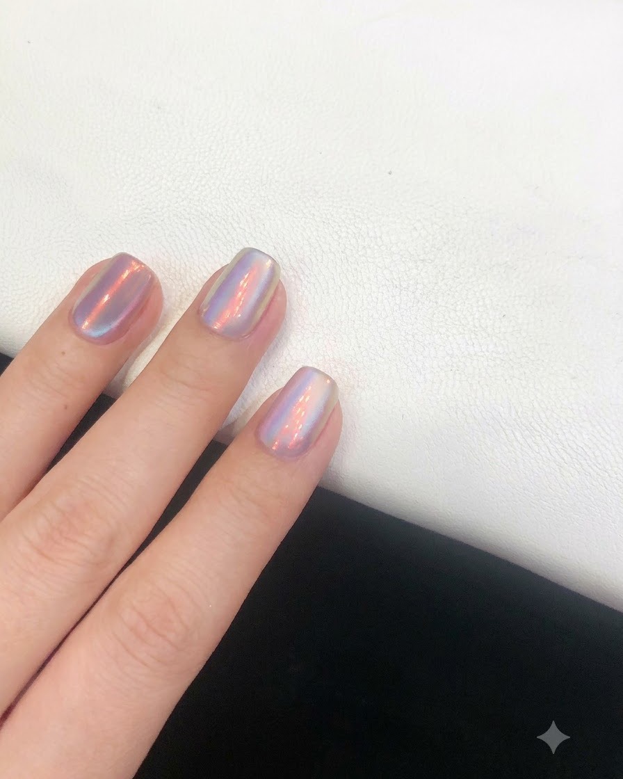Un pinceau de top coat glissant en douceur sur longle à effet aurore terminé pour sceller le design.