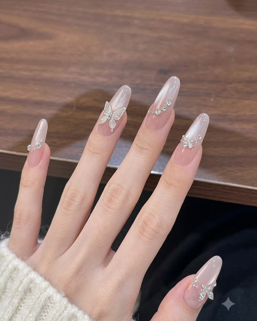 Main inclinée sous une lumière douce pour afficher leffet œil-de-chat nacré lumineux sur des ongles longs en amande.