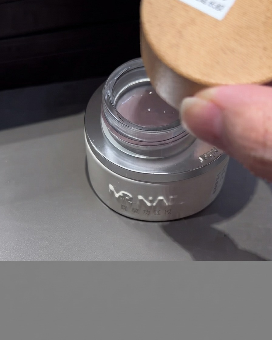 Un pot de gel dextension milky avec un couvercle en bois ouvert, montrant le gel translucide laiteux à lintérieur.
