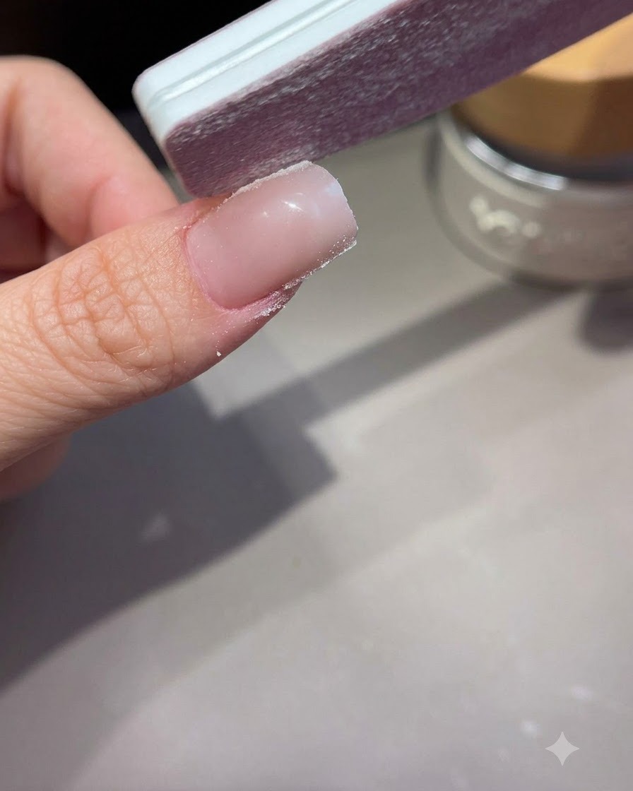 Une lime à ongles façonnant et lissant les parois latérales dun ongle en acrylique ou en gel étendu.