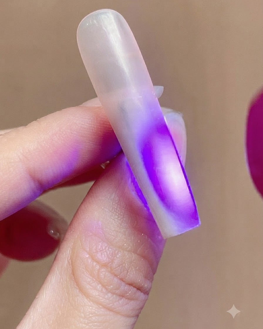 Un onglet illuminé par une lumière UV violette provenant dune lampe à ongles pendant le processus de catalysation.