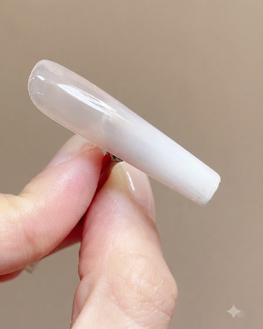 Un ongle catalysé lisse et brillant montrant un reflet clair de la lumière sur sa surface.