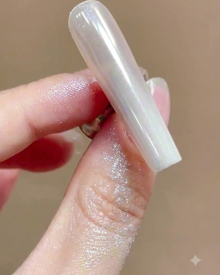 Une brosse douce balayant lexcès de poudre chatoyante dun ongle manucuré chrome ultra-brillant.