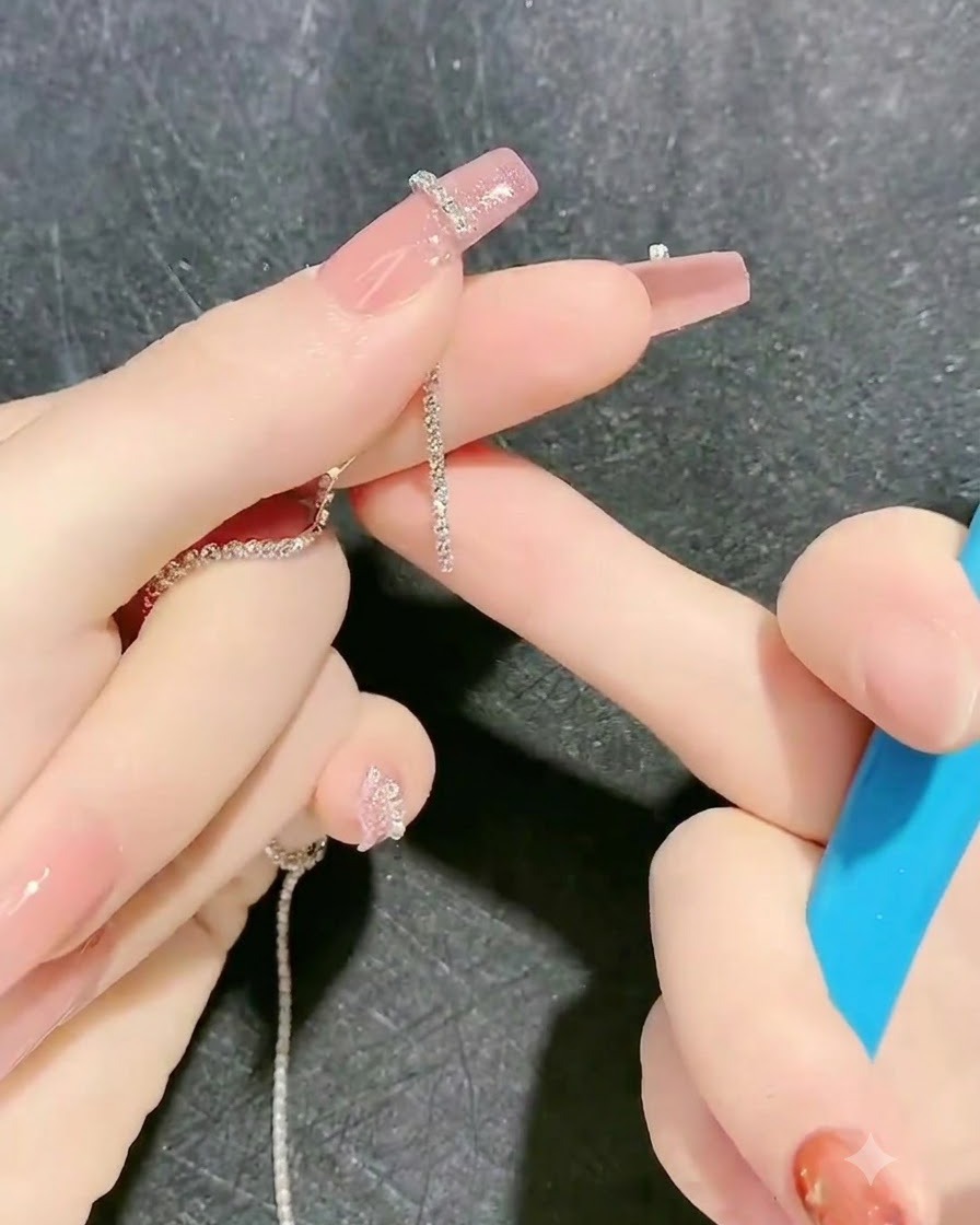 Un outil posant une bande de chaîne de strass sur le contour en gel collant dun doigt.