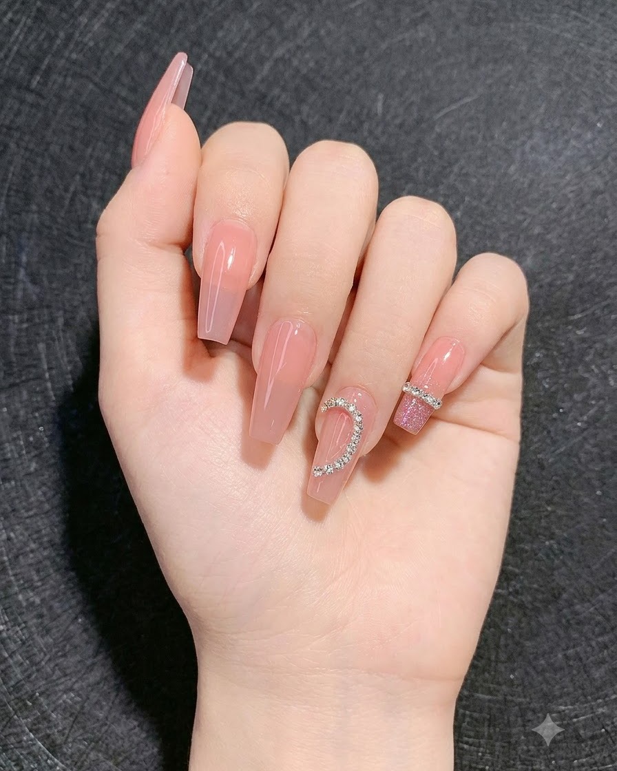 Une main présentant des ongles finis avec un dégradé disco scintillant sur les doigts adjacents et un motif de cœur en strass.